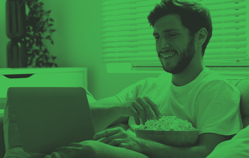 Homem assistindo filme e comendo pipoca