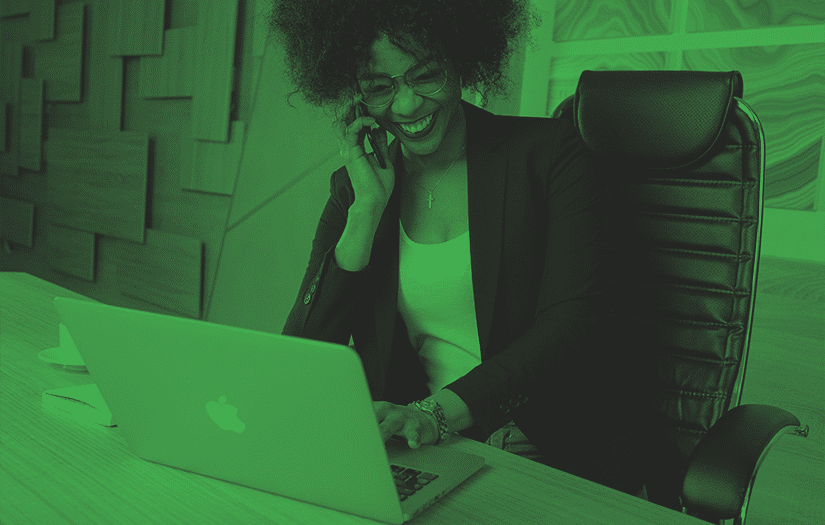 mulher de negócios utilizando um notebook e falando ao celular